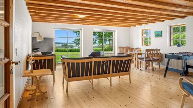 Una stanza con soffitto in legno, un divano, un tavolo e un tavolo da calcio.