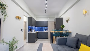 Una sala de estar moderna con un sofá gris, una mesa de centro de madera y un tapete azul.