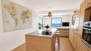 Eine moderne Küche mit Holzausstattung, einer zentralen Kochinsel und einer Weltkarte an der Wand.