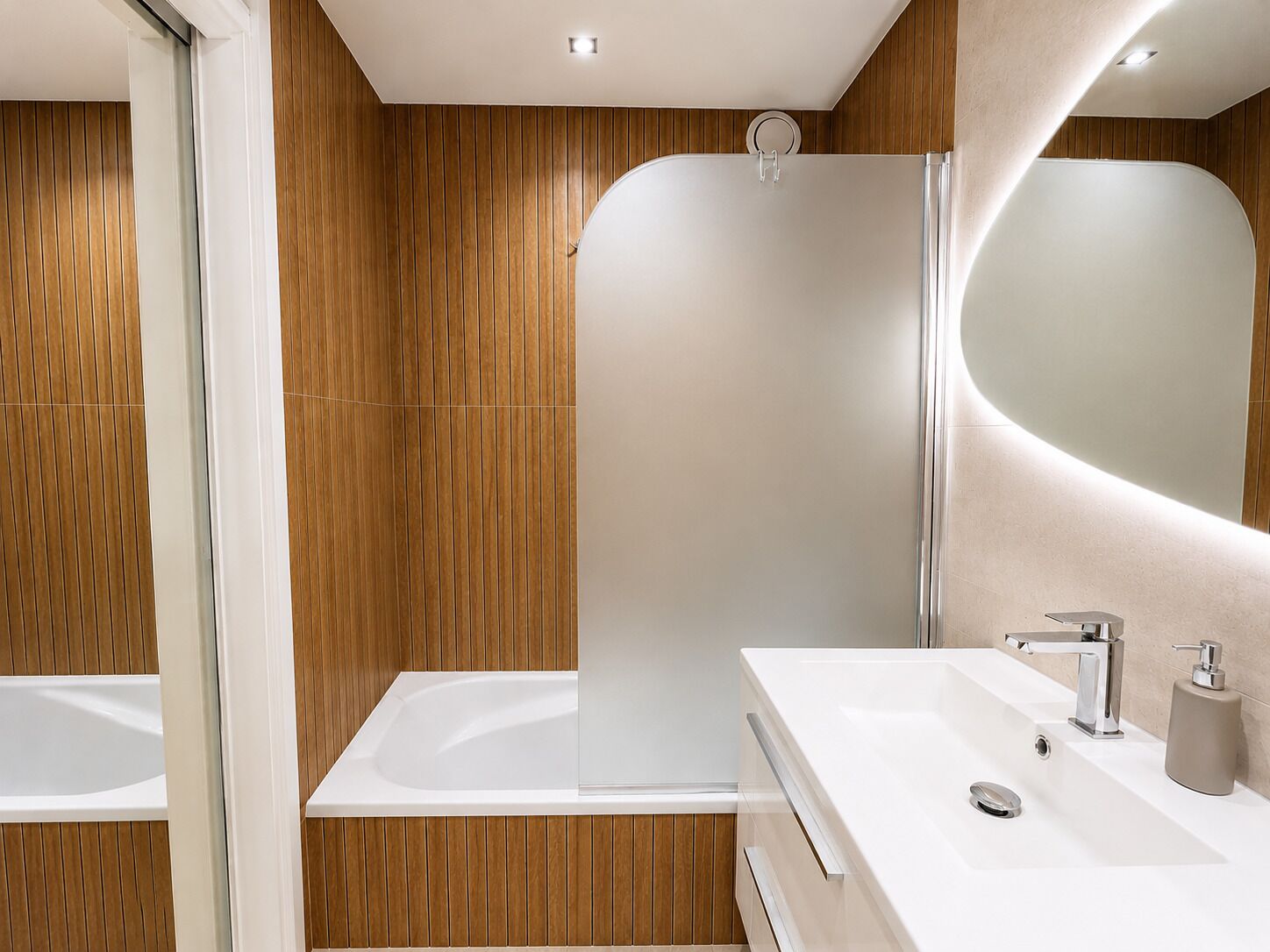 A modern bathroom with a bathtub, a shower enclosure, and a vanity with a mirror.