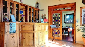 A reception area with wooden cabinets, a desk, and various informational signs. - Agriturismo Villa Guarnaschelli (Scandicci)