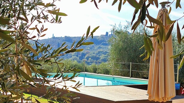 A table set outdoors with a pool in the background. - Agriturismo Villa Guarnaschelli (Scandicci)