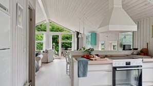 A modern kitchen with a large island, white cabinetry, and a view of the outdoors. - "Tekla" -  from the sea by Interhome (Rørvig)
