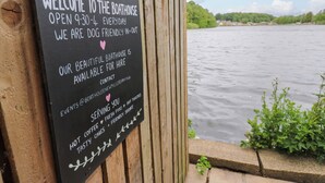 Une pancarte accueillant les visiteurs d’un abri à bateaux, ouvert de 9h30 à 21h30, où les chiens sont les bienvenus, et qui peut être loué.