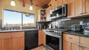 Une cuisine moderne avec des meubles en bois, une cuisinière en acier inoxydable et un four à micro-ondes.