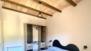 Un dormitorio con cama, armario y radiador.