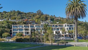A multi-story hotel with a modern architectural design, located on a hillside with a view of the surrounding area.