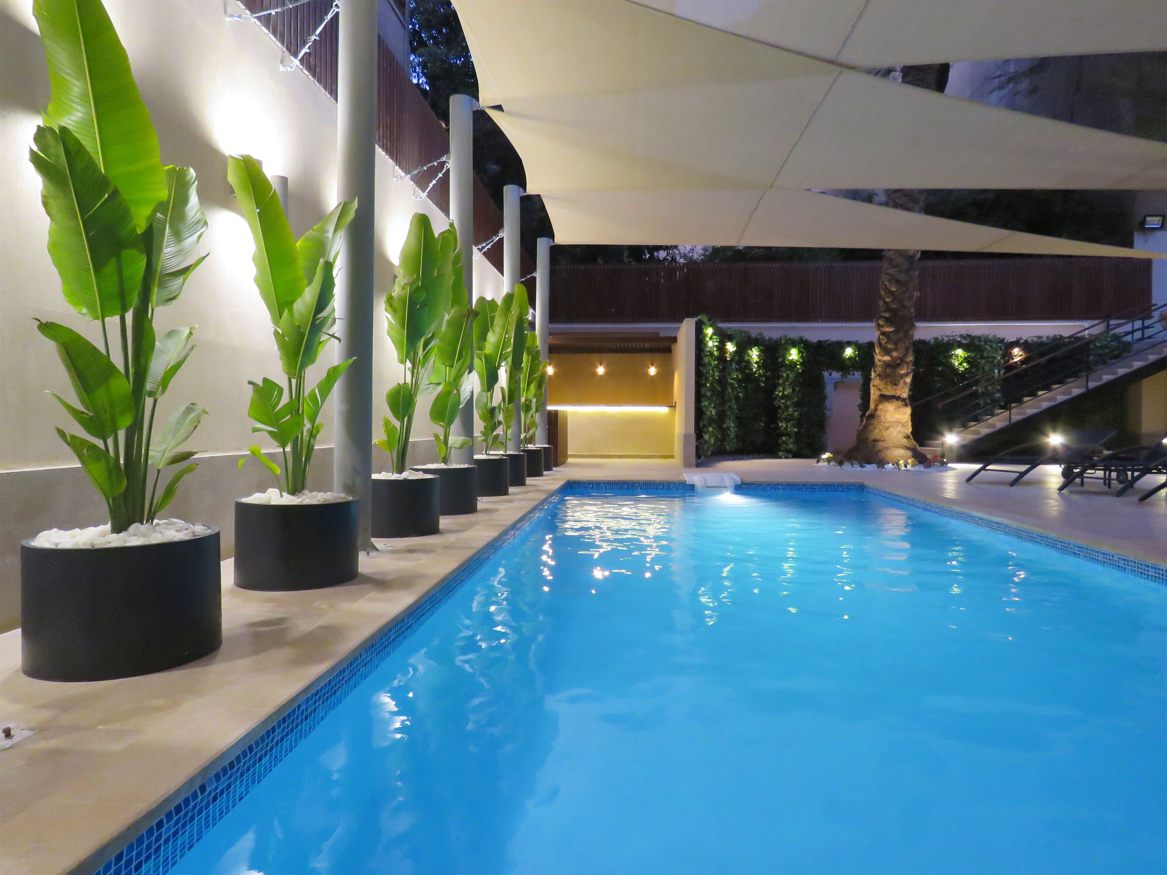 Una piscina al aire libre, sillones reclinables de piscina