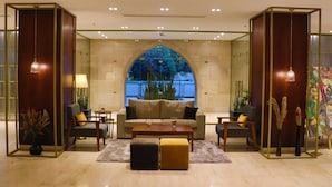 Eine moderne Lobby mit einer Couch, Sesseln, einem Couchtisch und einer dekorativen Vase.