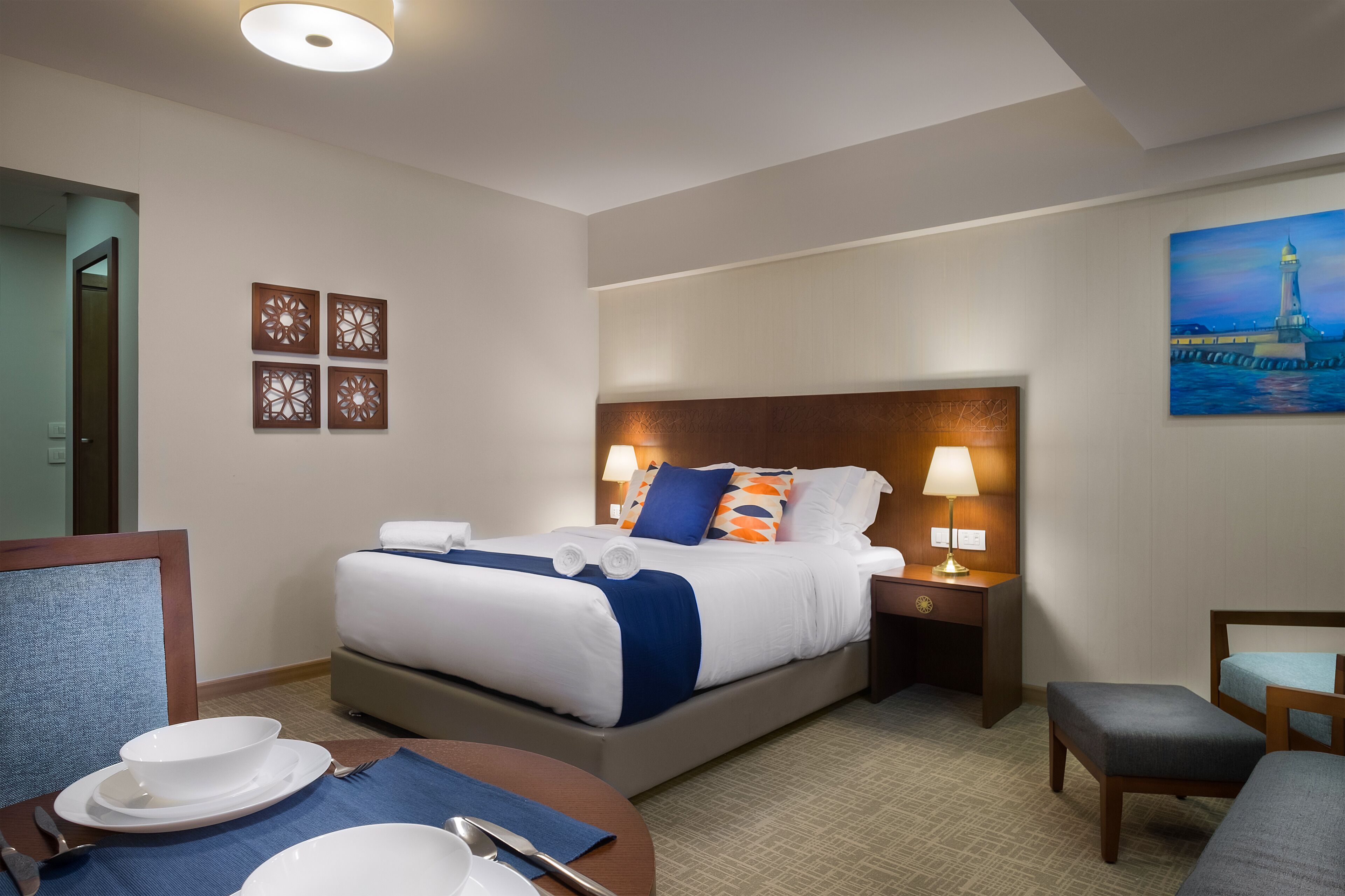 Een hotelkamer met een bed, nachtkastjes, een bureau en een eethoek.