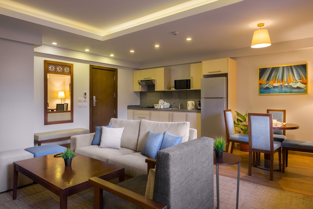 A modern living room with a sofa, coffee table, and dining area.