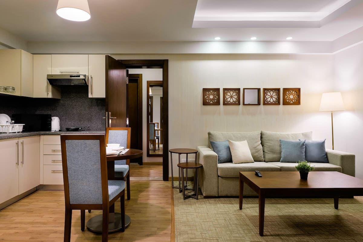A modern living room with a sofa, coffee table, and dining area.