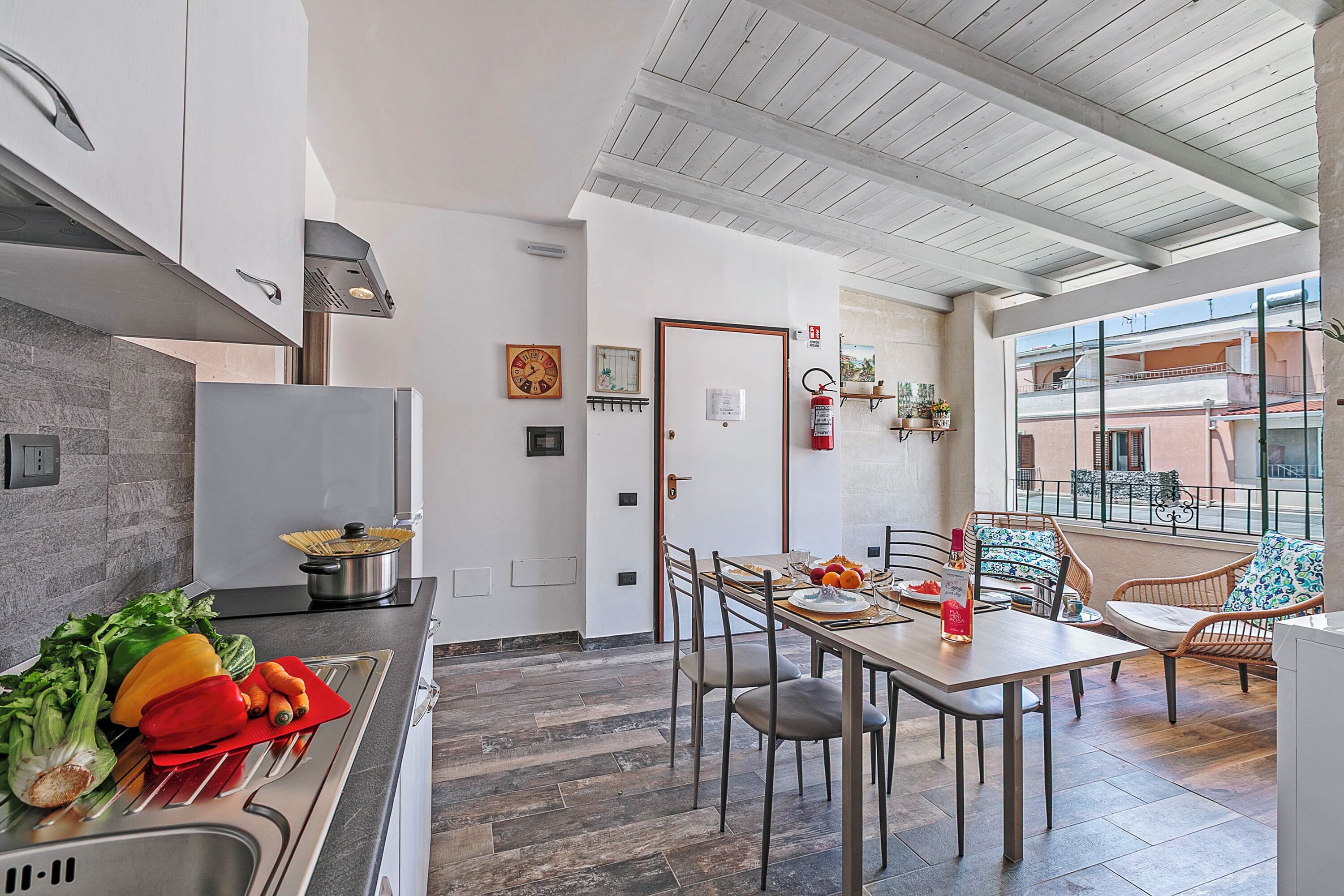 Una cocina moderna con comedor, suelo de madera y vistas a la ciudad a través de amplios ventanales.
