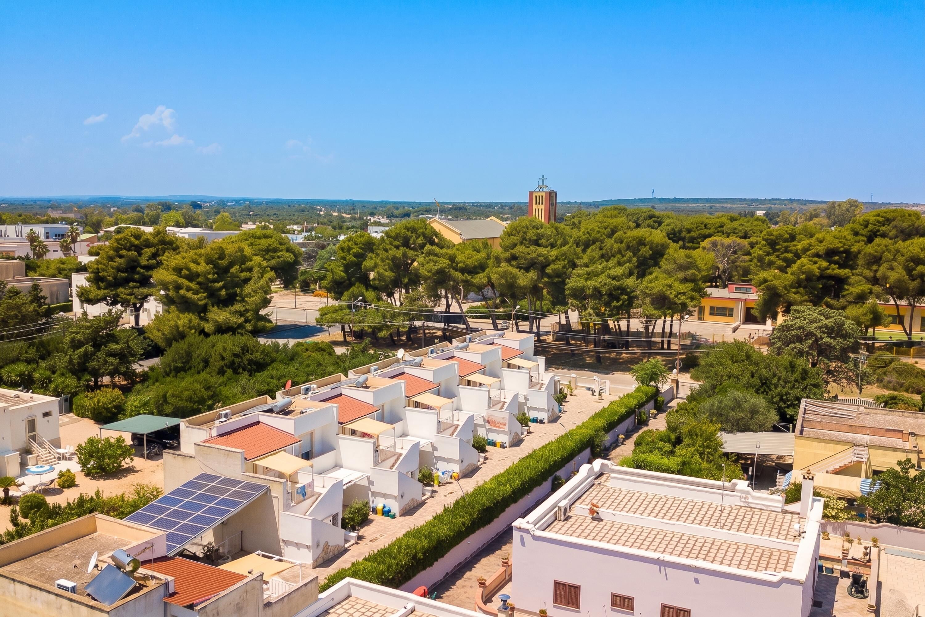 A residential area with modern houses, a church, and a clear blue sky.