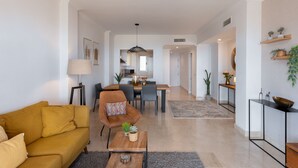 Un salon moderne comprenant un canapé, un fauteuil, une table basse et un coin repas.