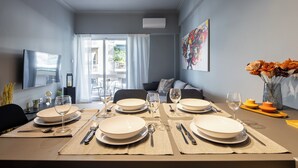 A dining area with a table set for four, including plates, cutlery, and glasses. - Zephyr 3-Bedroom Apartment in Athens (Athens)