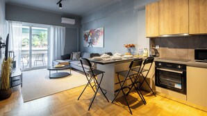 A modern kitchen with a dining area, wooden cabinets, and a large window. - Zephyr 3-Bedroom Apartment in Athens (Athens)