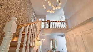 A staircase with white balusters and a wooden handrail leading to a second-floor balcony. - Villa Limon (Kusadasi)