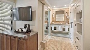 Un baño moderno con un espejo grande, un tocador con lavabo y una zona de ducha.