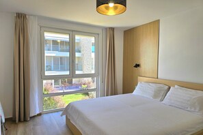 Enjoy a restful stay in this spacious room with a large bed, natural views, and a window overlooking the surrounding landscape.