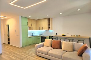 Cozy living space with a kitchenette, sofa, and dining table.