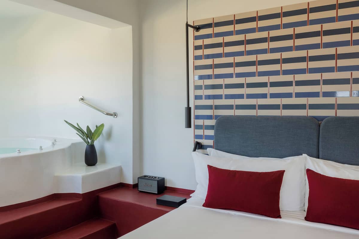 Een moderne badkamer met een badkuip, een klein plantje en een radio.