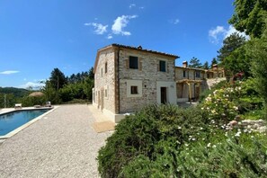 A stone building with a pool and a garden.