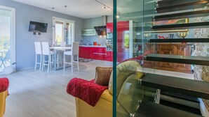 Un intérieur moderne comprenant un coin repas, une cuisine et un escalier.