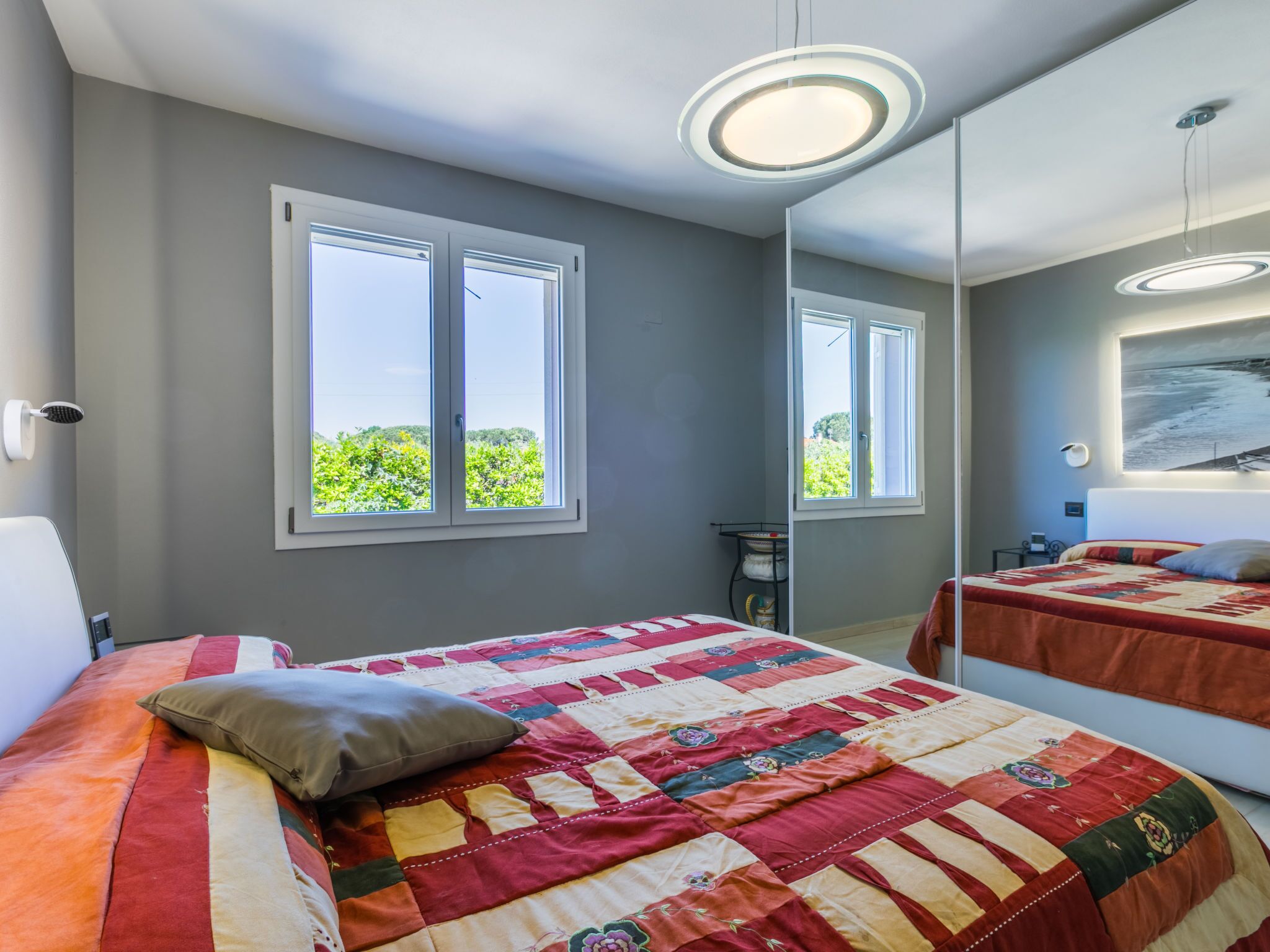 Un dormitorio con una cama grande, una ventana y un espejo.