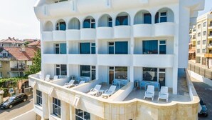 A multi-story hotel with balconies and outdoor seating areas. - Hotel Laguna Spa (Nessebar)