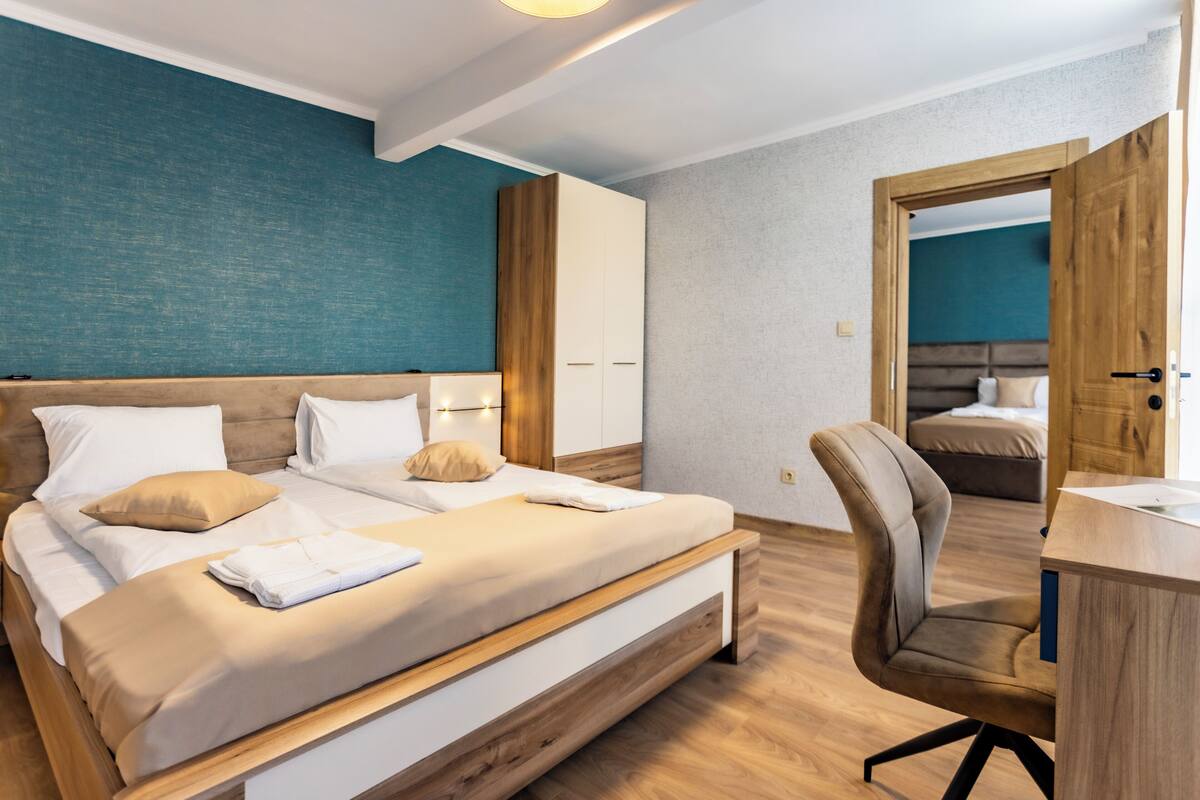 A modern bedroom with a bed, a desk, and a chair.