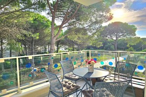 Enjoy a serene view of the surrounding landscape from this outdoor balcony, featuring a stylish table and chairs.
