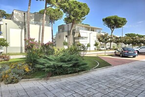 Two-story buildings with balconies and well-manicured landscaping surround a quiet residential area.