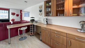 A compact kitchen with wooden cabinets, a bar area with stools, and a small refrigerator. - Gorgeous home in Lemmer with WiFi (Lemmer)
