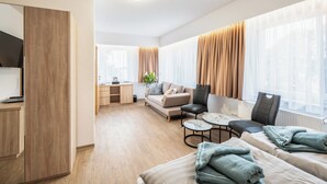 A modern hotel room with a sofa, two armchairs, a small table, and a bed. - Resort Dreistern - DZ 13, DZ 13 - Pension Resort Dreistern (Göda)