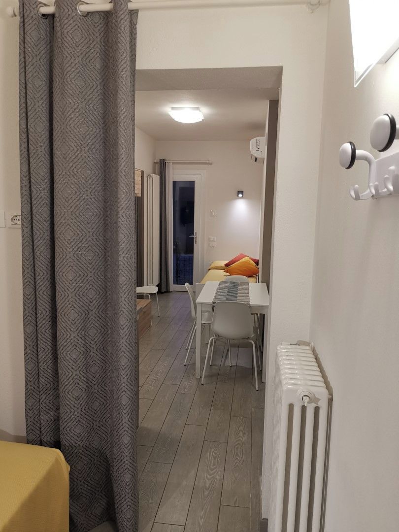 Una habitación moderna con comedor, radiador y cortina.