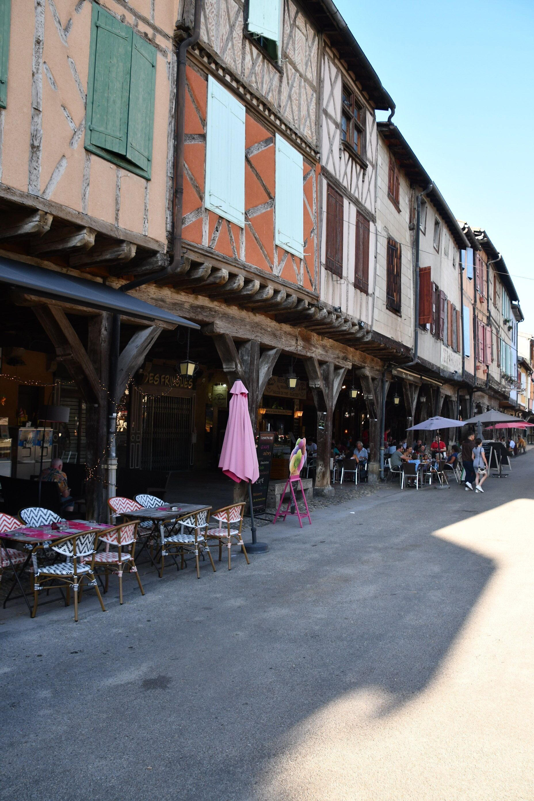 A traditional European street with outdoor seating and a café.