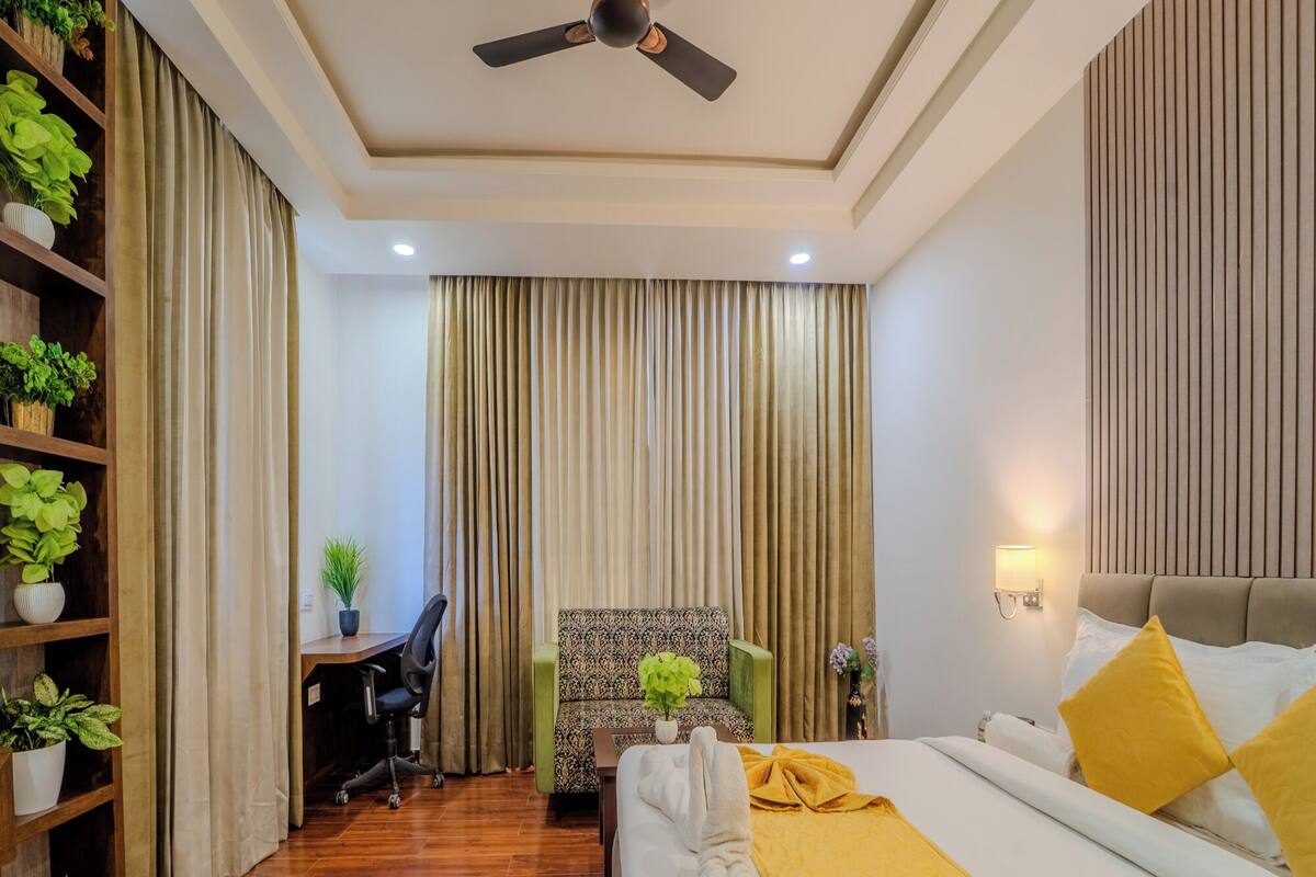 Une chambre d’hôtel équipée d’un lit, d’un bureau, d’une chaise et d’un ventilateur de plafond.
