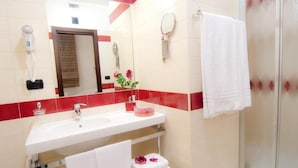 A bathroom with a white sink, a mirror, a hairdryer, and a shower. - B&B Vescovo Rosso (Cosenza)