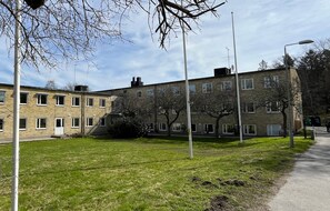 En bygning med mange vinduer, en græsplæde og en sti.