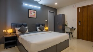 A modern bedroom with a large bed, two bedside tables with lamps, a wardrobe, and a desk with a chair. - Housr 84 Kondapur Near Botanical Garden (Hyderabad)
