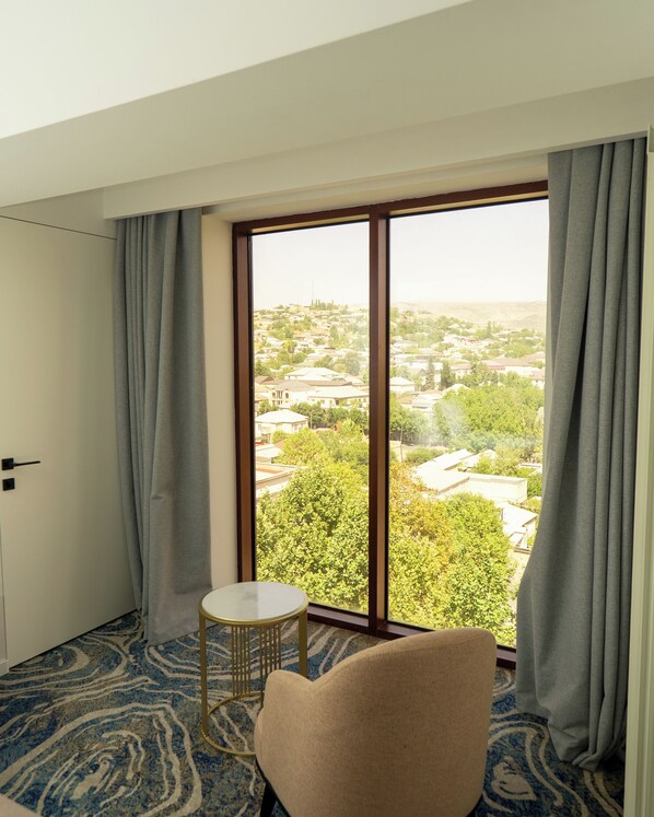 A room with a large window, a round table, and a chair.