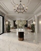 Un lobby lujoso con piso de mármol, una mesa redonda central y un candelabro.