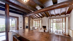 A rustic interior with a wooden bar, stone walls, and large windows. - Villa Maria with private pool (Moniga del Garda)