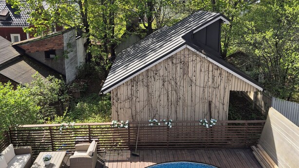 A wooden deck with a swimming pool, wicker furniture, and a small shed with vines. - Villa Mosahiisi Charming Poolside Getaway (Helsinki)