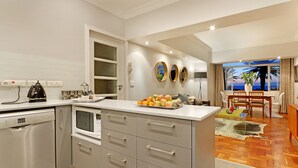 Una cocina moderna con lavavajillas, microondas y un frutero sobre la encimera.
