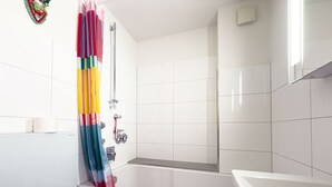 Une salle de bain avec une baignoire, une douche et des toilettes.