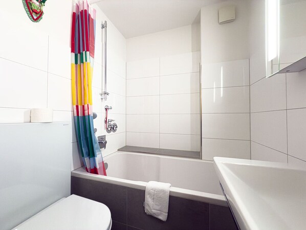 A bathroom with a bathtub, a shower, and a toilet.