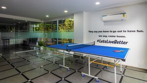 A ping pong table in a modern indoor space with glass walls, a potted plant, and a motivational quote on the wall. - Housr 43 Gachibowli Near DLF Cybercity (Hyderabad)