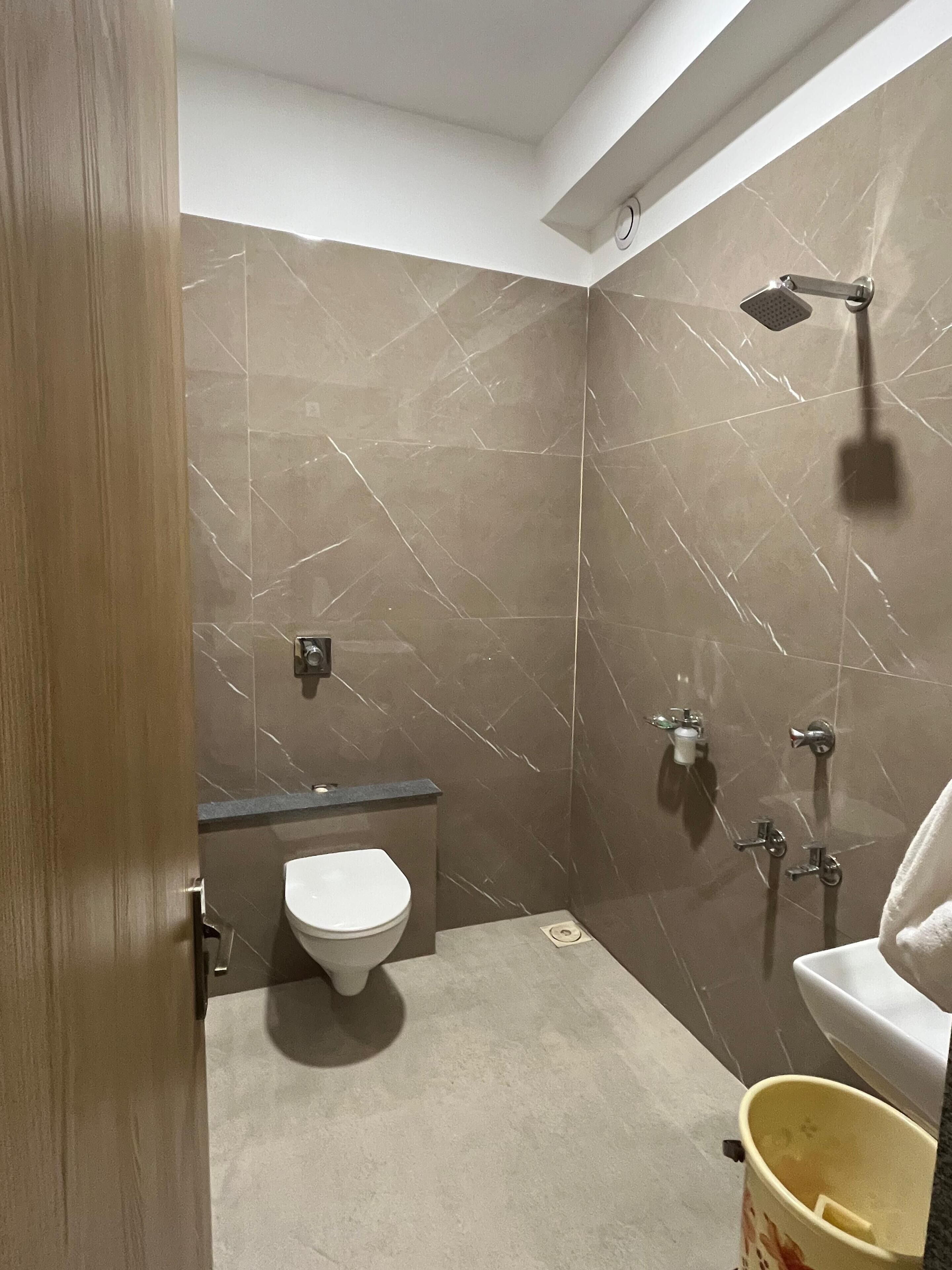 A modern bathroom with a toilet, sink, and shower.